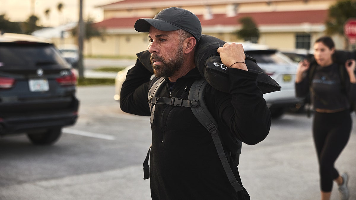 a person carrying the weight of a sandbag